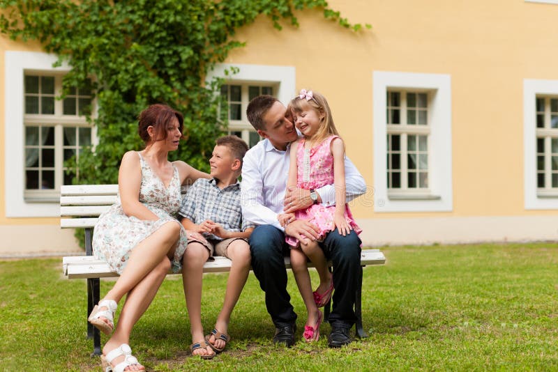 Family sitting in front of their home