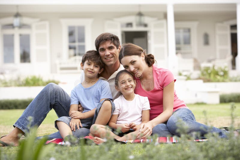 Family Sitting Outside House On Lawn royalty free stock photos