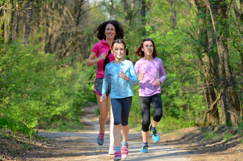 Family sport, happy active mother and kids running in forest stock images Family sport, happy active mother and kids running in forest stock images