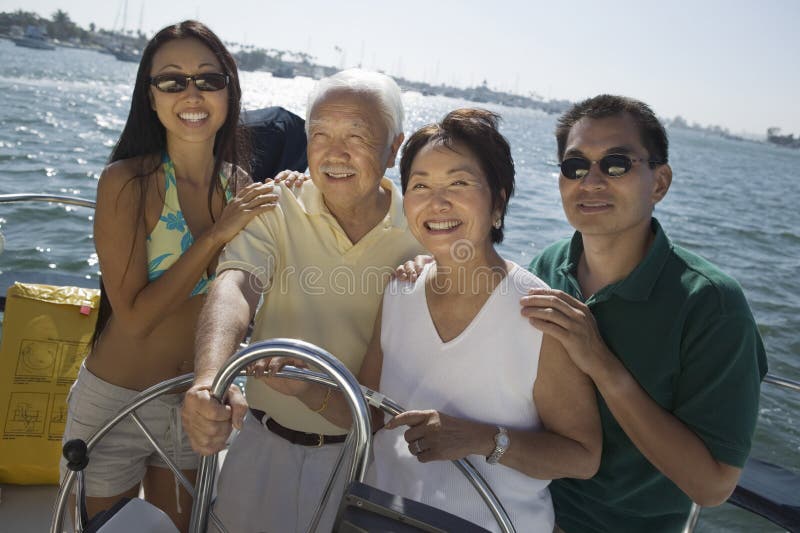 Family At Steering Wheel Of Sailboat