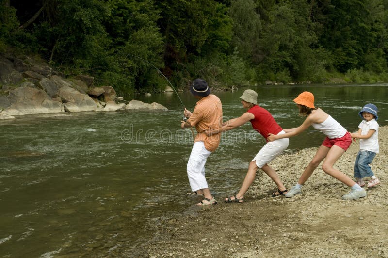 Co-operativo famiglia, la pesca nel fiume di montagna.