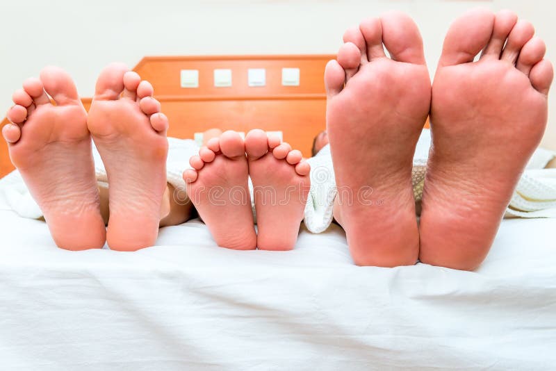 Family of three people sleeping in one bed