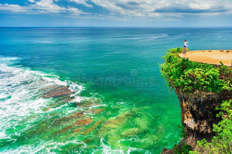 Family vacation lifestyle concept. Travel girl enjoy nature landscape island Bali from top mountain cliff Balangan beach Bali Indonesia Silhouette excited girl standing on mountain cliff and enjoying breathtaking view natural landscape tropical beach Bali Traveler excited woman enjoy amazing nature landscape tropical beach Bali from top of mountain cliff. Family vacation lifestyle concept. Travel girl enjoy nature landscape island Bali from top mountain cliff Balangan beach Bali Indonesia Silhouette excited girl standing on mountain cliff and enjoying breathtaking view natural landscape tropical beach Bali Traveler excited woman enjoy amazing nature landscape tropical beach Bali from top of mountain cliff