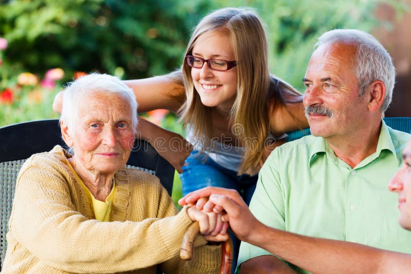 Le donne anziane di accogliere la sua famiglia, il figlio e la nipotina in giardino casa di cura.