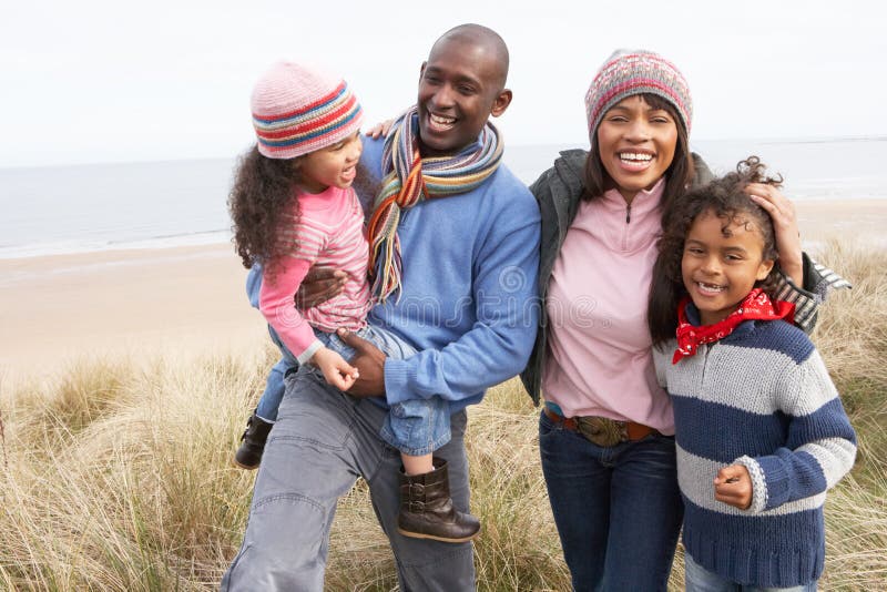 Family Walking Along Dunes On Winter Beach