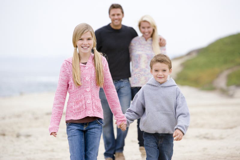 Family walking at beach holding hands