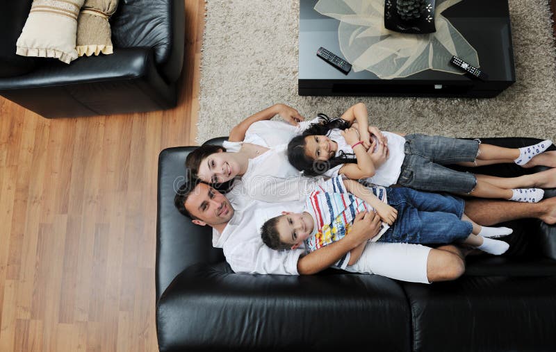 Family wathching flat tv at modern home indoor