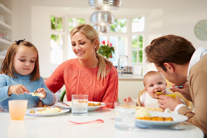Family With Young Baby Eating Meal At Home Stock Photo - Image of