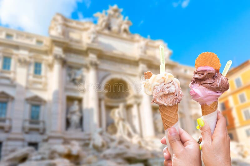 Famous landmark fountain di Trevi in Rome, Italy during summer sunny day with italian ice cream gelato in the foreground