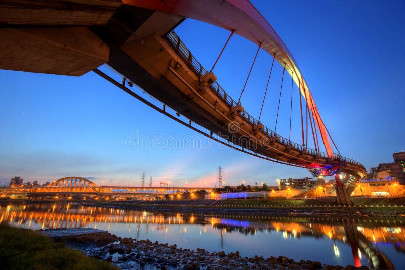 The famous Rainbow Bridge over Keelung River with reflections on smooth water at dusk in Taipei, Taiwan, Asia royalty free stock photo The famous Rainbow Bridge over Keelung River with reflections on smooth water at dusk in Taipei, Taiwan, Asia royalty free stock photo
