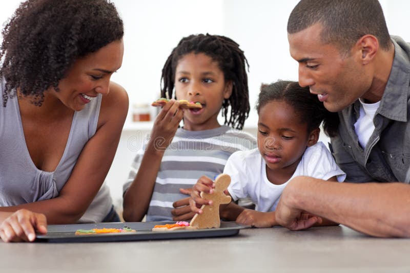 Happy Afro-American family eating homemade biscuits in the kitchen. Happy Afro-American family eating homemade biscuits in the kitchen