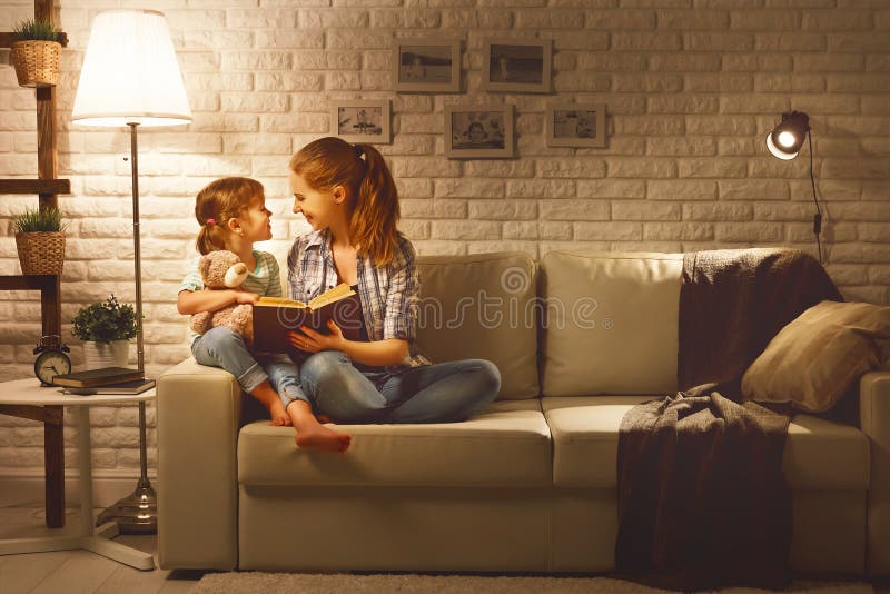 A família antes da mãe indo para a cama lê a sua filha BO da criança imagens de stock A família antes da mãe indo para a cama lê a sua filha BO da criança imagens de stock