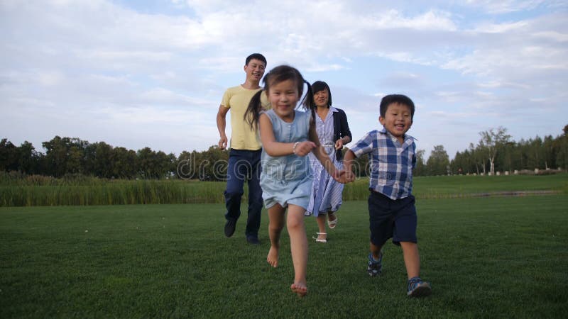 Família asiática despreocupada que aprecia o lazer na natureza