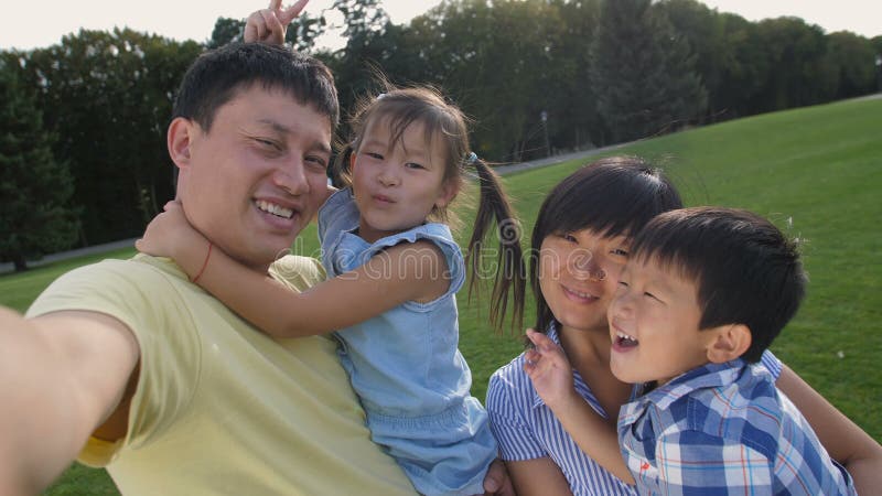 Família asiática feliz que faz o autorretrato no telefone