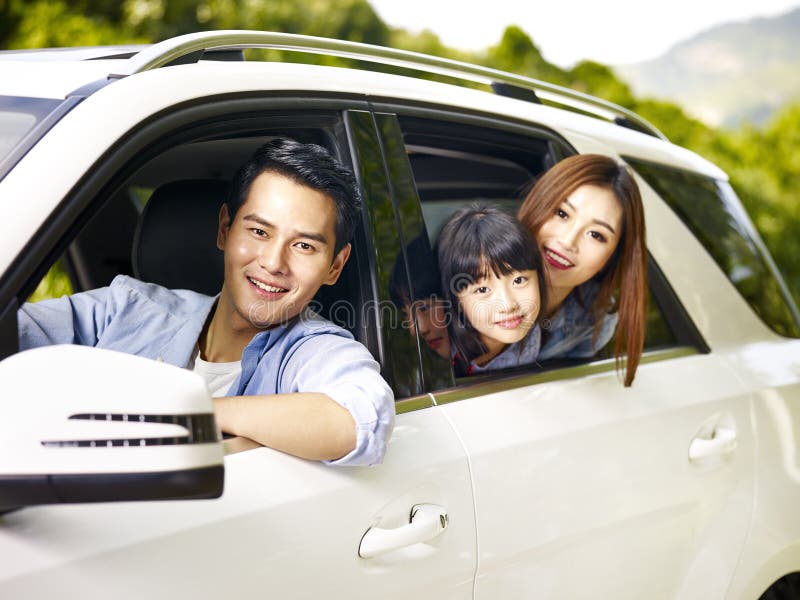 Família asiática que viaja pelo carro