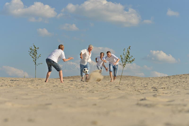 Família ativa alegre que joga o futebol fotografia de stock royalty free Família ativa alegre que joga o futebol fotografia de stock royalty free