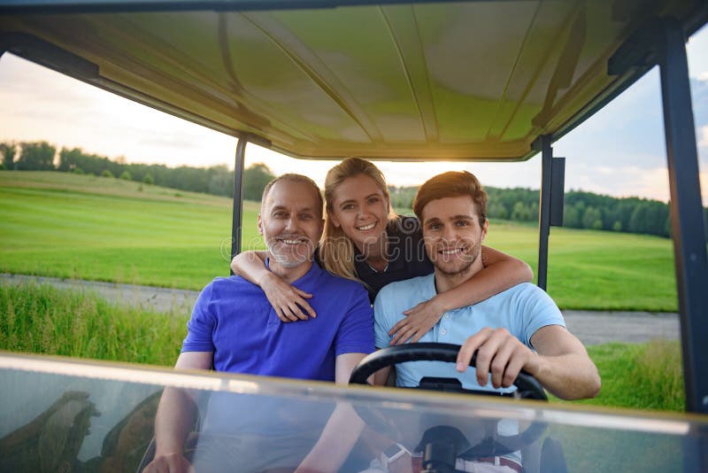 Família atrativa em seu carrinho de golfe imagens de stock royalty free Família atrativa em seu carrinho de golfe imagens de stock royalty free
