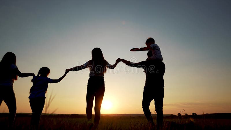 Família atravessa o campo. conceito de infância feliz para criança pequena. grande família feliz caminha pelo campo na