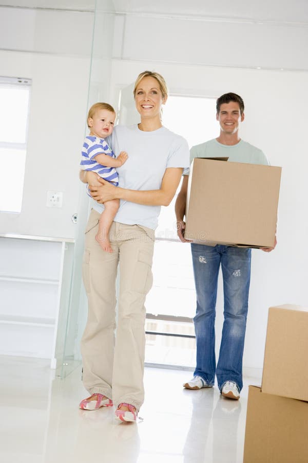Família com a caixa que move-se no sorriso home novo imagem de stock royalty free Família com a caixa que move-se no sorriso home novo imagem de stock royalty free