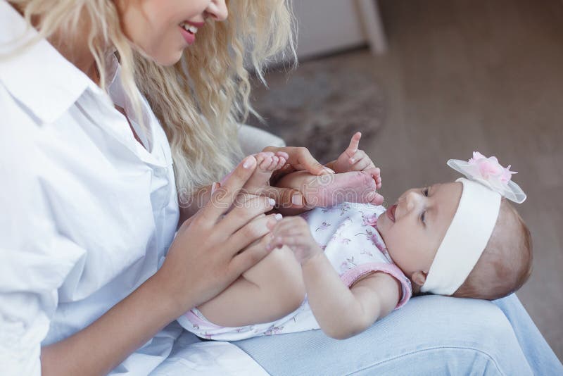 Família, criança e conceito da maternidade - mãe de sorriso feliz com a filha pequena do bebê em casa fotografia de stock Família, criança e conceito da maternidade - mãe de sorriso feliz com a filha pequena do bebê em casa fotografia de stock