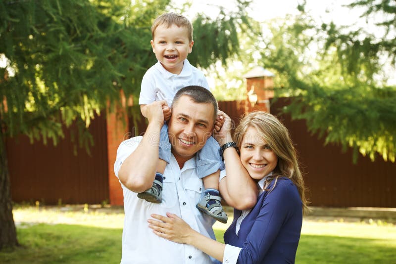 Família de jogo feliz fora pais novos com o filho no verão Mamã, paizinho e criança foto de stock Família de jogo feliz fora pais novos com o filho no verão Mamã, paizinho e criança foto de stock