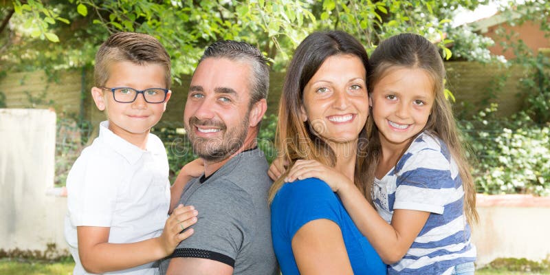 Família de quatro pessoas feliz no parque do jardim do campo fotos de stock Família de quatro pessoas feliz no parque do jardim do campo fotos de stock