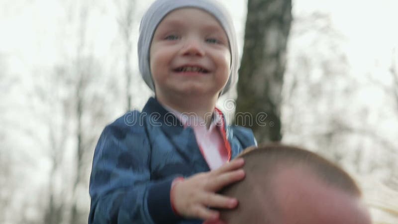 Família de três feliz que anda na primavera parque