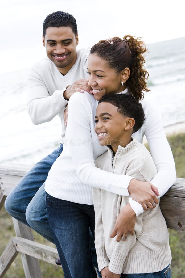 Família do African-American que abraça na praia foto de stock Família do African-American que abraça na praia foto de stock