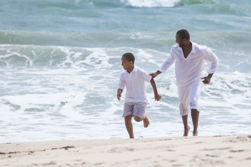 Família do filho do pai do americano africano na praia