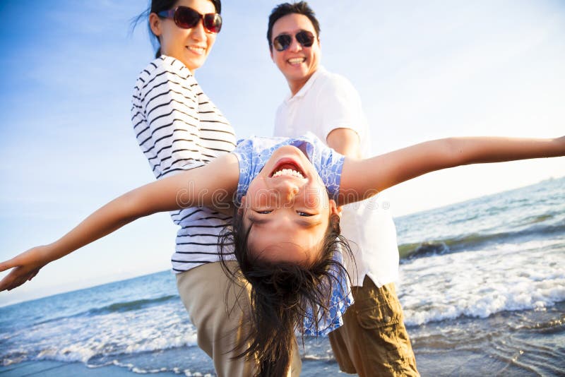 A família feliz aprecia férias de verão na praia imagem de stock A família feliz aprecia férias de verão na praia imagem de stock