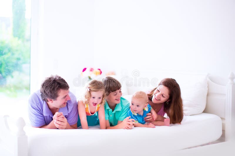 Família feliz com as três crianças no quarto foto de stock Família feliz com as três crianças no quarto foto de stock