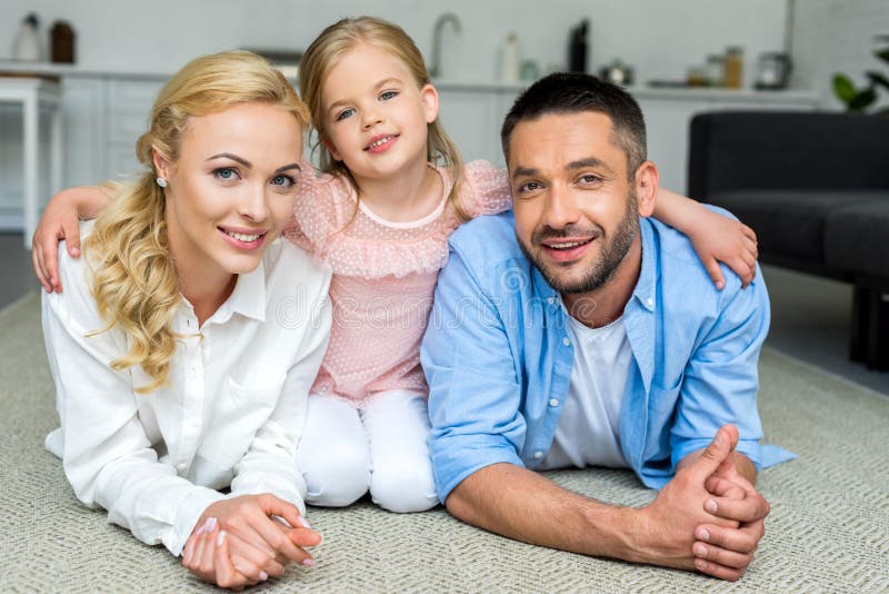 família feliz com a uma criança que sorri na câmera imagens de stock royalty free família feliz com a uma criança que sorri na câmera imagens de stock royalty free