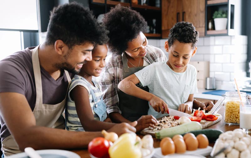 Família feliz na cozinha se divertindo e cozinhando juntos Alimentos saudáveis em casa