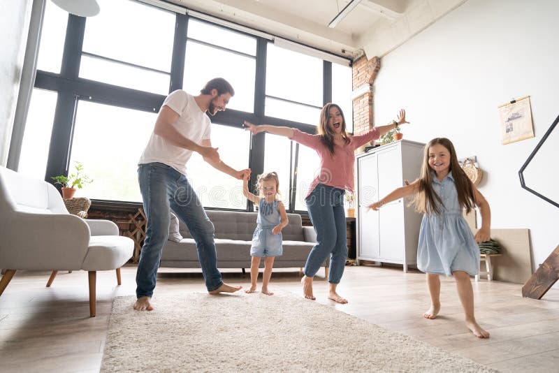 Família feliz pai e filha criança dançando em casa.