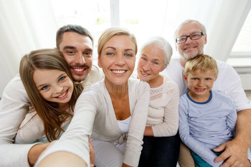 Família feliz que faz o selfie em casa