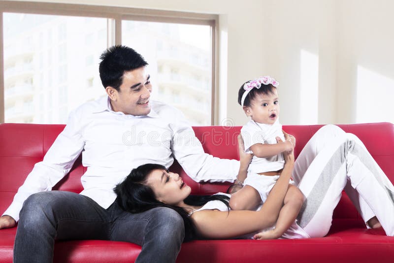 Família feliz que joga no sofá fotos de stock Família feliz que joga no sofá fotos de stock