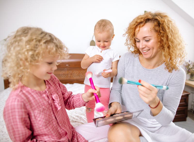 Família feliz que joga truques no quarto fotografia de stock Família feliz que joga truques no quarto fotografia de stock