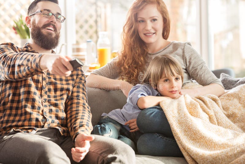 Família feliz que presta atenção à tevê junto foto de stock Família feliz que presta atenção à tevê junto foto de stock