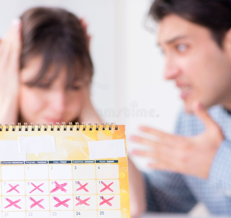 Young family in pregnancy planning concept with ovulation calendar. Young family in pregnancy planning concept with ovulation calendar