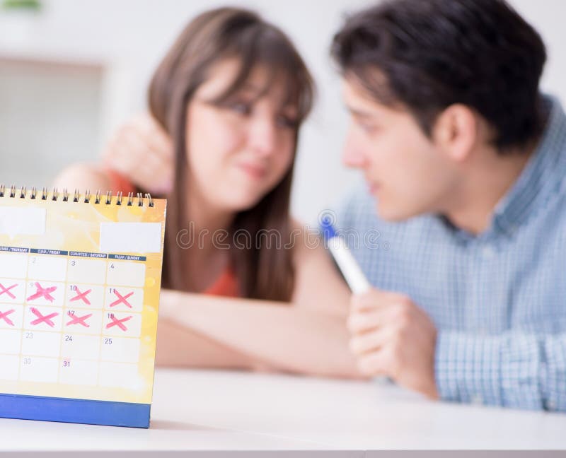 Young family in pregnancy planning concept with ovulation calendar. Young family in pregnancy planning concept with ovulation calendar