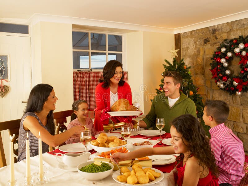 Família latino-americano em casa que sere o jantar do Natal imagens de stock Família latino-americano em casa que sere o jantar do Natal imagens de stock