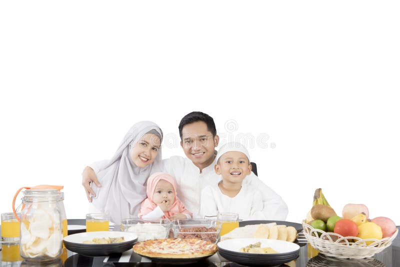 Família muçulmana que tem a refeição na mesa de jantar fotografia de stock Família muçulmana que tem a refeição na mesa de jantar fotografia de stock