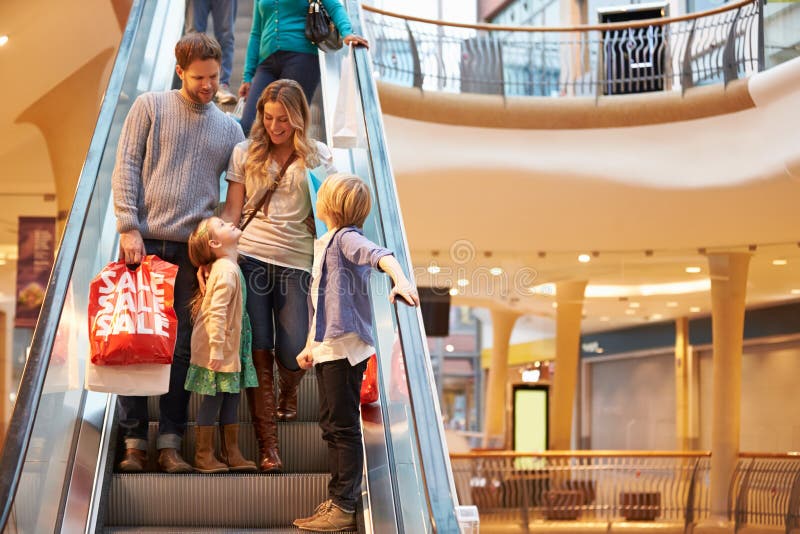 Família na escada rolante no shopping junto