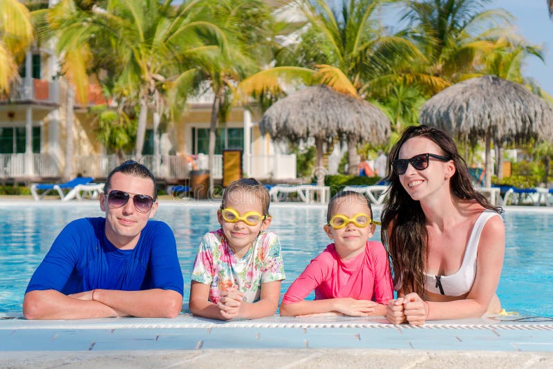 A família nova com duas crianças aprecia férias de verão na associação exterior fotografia de stock royalty free A família nova com duas crianças aprecia férias de verão na associação exterior fotografia de stock royalty free