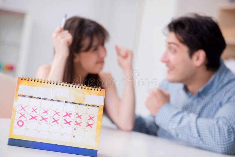 Young family in pregnancy planning concept with ovulation calendar. Young family in pregnancy planning concept with ovulation calendar