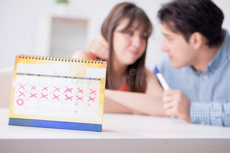 Young family in pregnancy planning concept with ovulation calendar. Young family in pregnancy planning concept with ovulation calendar