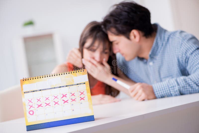Young family in pregnancy planning concept with ovulation calendar. Young family in pregnancy planning concept with ovulation calendar