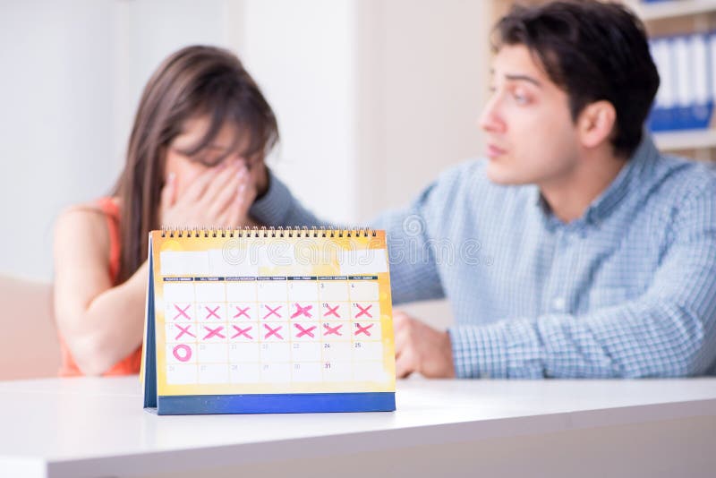 Young family in pregnancy planning concept with ovulation calendar. Young family in pregnancy planning concept with ovulation calendar