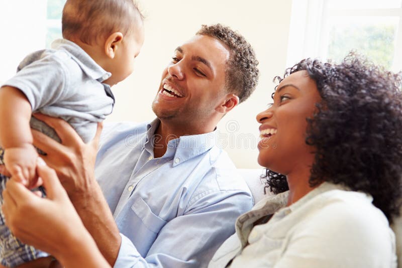 Família nova que joga com o filho feliz do bebê em casa imagem de stock royalty free Família nova que joga com o filho feliz do bebê em casa imagem de stock royalty free