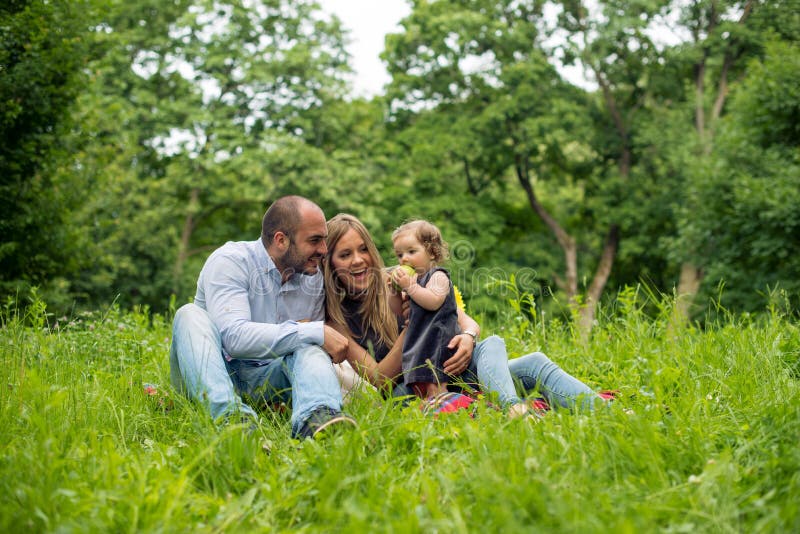 Família nova que joga na natureza imagens de stock Família nova que joga na natureza imagens de stock